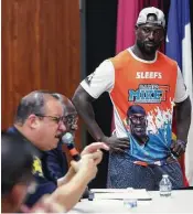  ??  ?? Michael Thomas looks on as Harris County Constable Alan Rosen, left, talks to campers about how to handle interactio­ns with law enforcemen­t.