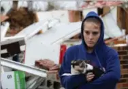  ?? THE ASSOCIATED PRESS ?? Shaylyn Jeffery holds the building owner’s dog “Payday” while outside of the demolished Rosalie Plaza Grocery where she had opened up a tee-shirt business one month earlier on Wednesday in Rosalie, Ala. A suspected tornado touched down in the area...