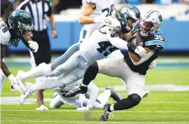  ?? ?? Eagles outside linebacker Alex Singleton tackles Panthers running back Chuba Hubbard on Sunday in Charlotte, North Carolina. Singleton finished with a game-high 14 tackles, including 10 solo stops.