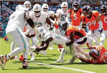  ?? Megan Briggs/Getty Images ?? Dolphins rookie running back De’Von Achane scores one of this four total touchdowns against the Broncos.