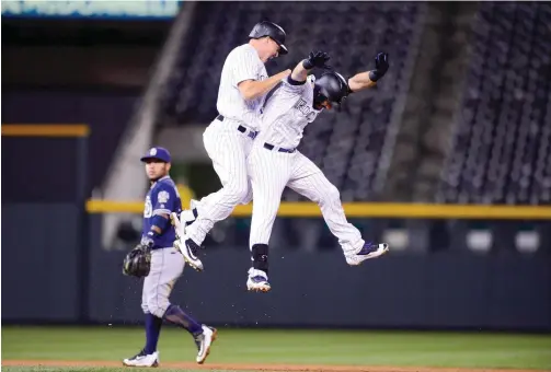  ??  ?? DENVER: Nick Hundley #4 and Daniel Descalso #3 of the Colorado Rockies celebrate after Descales hit a walk-off RBI single in the ninth inning of a game against the San Diego Padres at Coors Field on Friday in Denver, Colorado. —AFP
ROCKIES 8, PADRES 7