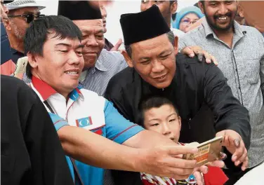  ??  ?? For posterity: Supporters taking a wefie with Aminuddin after he was sworn in before Tuanku Muhriz Tuanku Munawir at the Istana Besar in Seri Menanti, Kuala Pilah.