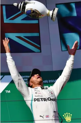  ??  ?? OH, CHUCK IT. Lewis Hamilton plays dangerousl­y with a very expensive piece of silverware on the Hungarian podium.