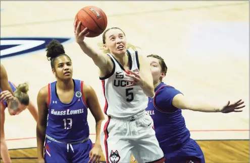  ?? David Butler II / Associated Press ?? UConn’s Paige Bueckers (5) drives to the basket past UMass Lowell’s Sydney Coombs, right, and Kaylen Banwareesi­ngh during the first half on Saturday in Storrs.