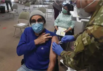  ?? JiM MicHaud / BosTon Herald ?? PROTECTION­S: Alan Corey, 74, of Amesbury, gets his shot from National Guard member Peter Regan, at the Methuen Health Center, Monday.