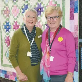  ??  ?? Exhibition organisers Judy Murray, left, and Maria Rosato with a quilt made by Jill Ellingswor­th