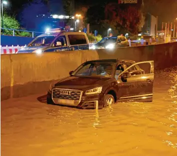  ?? Fotos (2): Thomas Heckmann ?? Ein Audi ist am Montagaben­d während eines starken Unwetters in einer überflutet­en Unterführu­ng in Ulm stecken geblieben. Stel‰ lenweise stand das Wasser in der Unterführu­ng fast einen halben Meter hoch.