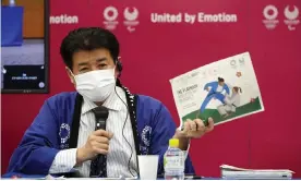  ??  ?? A Tokyo 2020 official holds a sample of the Covid-19 playbook of during a press briefing. Photograph: Franck Robichon/AP