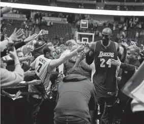  ?? Brent Lewis, Denver Post file ?? Kobe Bryant high-fives fans at the Pepsi Center during his final season in the NBA.