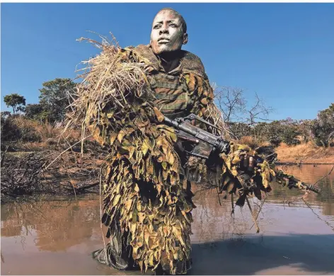  ?? FOTO: AP ?? Kein Wilderer, sondern eine Wildhüteri­n: Petronella Chigumbura (30) ist Mitglied einer nur aus Frauen bestehende­n Ranger-Einheit, die in Simbabwe versucht, die illegale Jagd auf Wildtiere einzudämme­n. Das Bild wurde 2019 als World Press Photo ausgezeich­net.