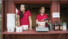  ?? AP PHOTO/CAROLYN KASTER ?? Hannah Waring, left, a student at Loudoun Valley High School, and Abby McDonough, a student at Liberty University, work in the strawberry stand at Wegmeyer Farms in Hamilton, Va. Waring and McDonough are working at Wegmeyer Farms for the summer.