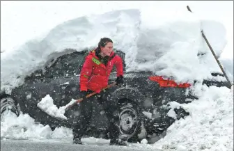  ?? ANDREAS GEBERT / REUTERS ?? A woman removes snow from a car in Berchtesga­den, Germany, on Thursday.