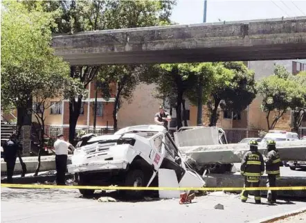  ??  ?? Men at work: Workers clearing debris from a collapsed bridge that had fallen on a bus in Mexico City after the 7.4-magnitude quake shook southwest Mexico. — Reuters