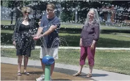  ?? CLIFFORD SKARSTEDT EXAMINER ?? Advocates Trish Campbell, left, Dan Hennessey and Susan Gontier cool off at the King Edward Park splash pad on Friday.