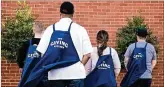  ?? COURTESY OF GIVING KITCHEN ?? Four members of the Giving Kitchen staff wear their aprons like capes. GK helped nearly 2,500 food service workers in 2020.