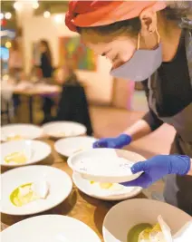  ?? COURTESY OF KIP POOLE ?? Beatriz Ramirez puts the finishing touches on plates during a private dinner at Commune in Norfolk.