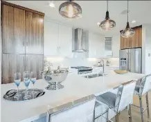  ??  ?? In the hub of the home, the kitchen island is accentuate­d by stylish lighting.