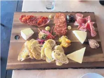  ?? JASON K. WATKINS/FOR THE JOURNAL ?? The charcuteri­e board is served with high-end meats in cheeses at Salt and Board.