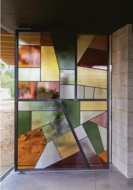  ?? ?? A stained-glass window, above, is based on an aerial map of Suisun Valley, with Caymus’ vineyards in yellow. Right: A vineyard and water tanks.