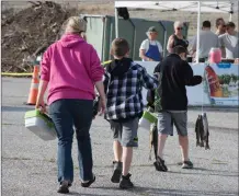  ??  ?? Courtesy photo Children walk away from Castaic Lake with fish they just caught. Friends of Castaic Lake urge volunteers who help clean the park to wear proper clothes for working outdoors, including close-toed shoes and gloves.