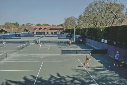  ?? ANDREW TESTA/THE NEW YORK TIMES ?? Players compete on the courts April 20 at West Hants Tennis Club in Bournemout­h, England. The club was the site of the first open tournament in tennis 50 years ago, ushering in a new era of profession­als and amateurs playing together.