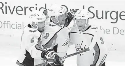  ?? BILL KOSTROUN/AP ?? Capitals left wing Alex Ovechkin (8) celebrates his 700th career goal with defensemen Michal Kempny (6) and Nick Jensen.