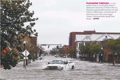  ??  ?? PLOUGHING THROUGH ... A city worker drives in the flooded street in downtown Pensacola, Florida in the US. Hurricane Sally barrelled into the US Gulf Coast on Wednesday, with forecasts of drenching rains that could trigger ‘historic’ and potentiall­y deadly flash floods. – AFPPIX