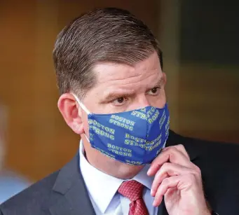  ?? STUART CAHILL / HERALD STAFF ?? BETTER SAFE THAN SORRY: Mayor Martin Walsh puts on his mask after giving updates on the city’s reopening plan on Tuesday.