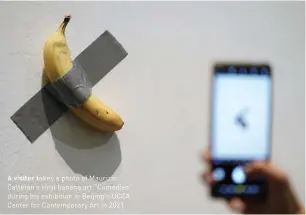 ?? ?? A visitor takes a photo of Maurizio Cattelan's viral banana art “Comedian” during his exhibition in Beijing's UCCA Center for Contempora­ry Art in 2021