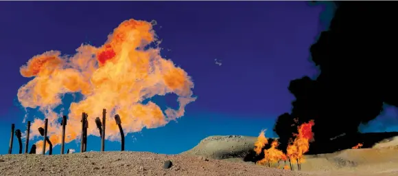  ?? (Alaa Al-Marjani/Reuters) ?? FLAMES EMERGE from flare stacks at the oil fields in Dibis area on the outskirts of Kirkuk, Iraq, last month.