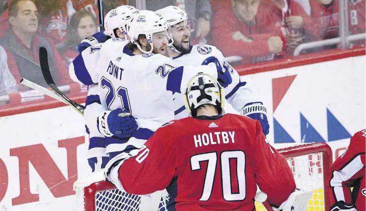  ?? NICK WASS/THE ASSOCIATED PRESS ?? Tampa Bay Lightning centre Brayden Point (21) celebrates his goal with centre Tyler Johnson (9) next to Washington Capitals goaltender Braden Holtby in the first period of Thursday night’s Eastern Conference final in Washington. The Lightning’s win...