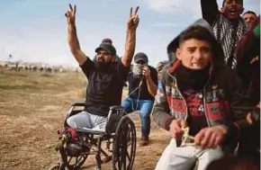  ??  ?? Wheelchair-bound Palestinia­n protester Ibrahim Abu Thuraya gesturing to Israeli soldiers at the Israeli-Gaza border on Friday before he was killed.
