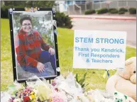  ?? David Zalubowski / Associated Press ?? A photograph of student Kendrick Castillo stands amid a display of tributes outside the STEM School Highlands Ranch a week after the attack on the school that left Castillo dead and others injured in Highlands Ranch, Colo.