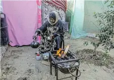  ?? ?? No home and no safety: A woman cooks food as she and other Palestinia­n families seek shelter in makeshift living spaces on the streets in Rafah, Gaza, after leaving their houses for safety.
/Abed Rahim Khatib/Anadolu via Getty Images