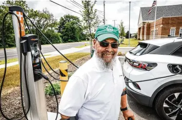  ?? JIM NOELKER / STAFF ?? Rap Hankins charges his Volkswagen ID.4 outside of Montgomery County Western Division Municipal Court in Trotwood. He is the president of Drive Electric Dayton and is an advocate for electric cars in underserve­d Black communitie­s.