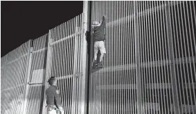  ?? GARY CORONADO / LOS ANGELES TIMES/TNS ?? Eduardo Olmos, 38, U.S. Border Patrol agent, apprehends a male Mexican, 54, of Guerrero, Mex., trying to climb the secondary fence into Border Field State Park, San Diego, from Playas de Tijuana, along the U.S.- Mexico border in San Diego, Calif., on...