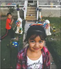  ??  ?? Dulce, 6, and her brother play March 9 in the yard of their family home across the railroad tracks in Burlington, N.C.