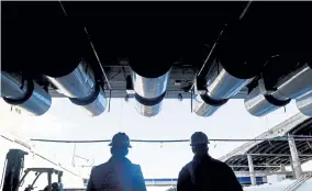  ?? AAron Ontiveroz, The Denver Post ?? Dan Virgilio, railroad design manager, right, and Matt Sanman, public informatio­n manager for Kiewit, walk out from beneath the new undergroun­d expansion of Interstate 70 in Denver’s Swansea neighborho­od.