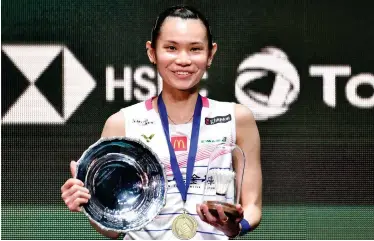  ?? Asscociate­d Press ?? ↑
Tai Tzu Ying poses with her trophy after beating Chen Yu Fei in the Women’s final at the All England Open on Sunday.
