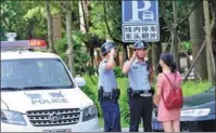  ?? PHOTOS PROVIDED TO CHINA DAILY ?? Top: Police personnel of the Zhangzhou 110 emergency call service help a woman who got lost in 2017. They have built a reputation of helping people quickly. Above: Two officers greet a citizen in need with a salute during patrol.