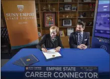  ??  ?? Photo providedNe­w York State Labor Department Commission­er Roberta Reardon signs an agreement to create the Empire State Career Connector.