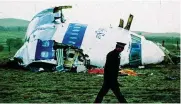  ?? MARTIN CLEAVER / AP ?? A police officer walks by the nose of Pan Am flight 103 in a field near the town of Lockerbie, Scotland, where it lay after a bomb aboard exploded, killing a total of 270 people on Dec. 21, 1988.