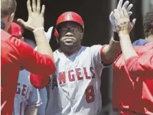  ?? AP PHOTO ?? MOTORING THROUGH DETROIT: Eric Young Jr. gets congratula­tions during yesterday’s Angels rout of the Tigers, who visit Fenway to face the Red Sox tonight.