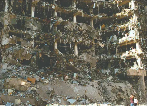  ?? (AP File/David Longstreat­h) ?? Rescue workers stand in front of the Alfred P. Murrah Federal Building following the bombing April 19, 1995, in downtown Oklahoma City. The explosion killed 168 people.