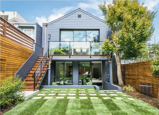  ?? Olga Soboleva/Vanguard Properties ?? The south-facing backyard of 121 Clipper St. in Noe Valley includes a level lawn, a shade tree, raised deck and a patio.