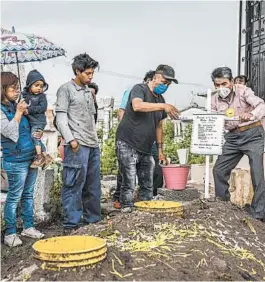  ?? DANIEL BEREHULAK/THE NEW YORK TIMES ?? Relatives bury a COVID-19 victim in July near Mexico City. While others minimized the virus early on, Claudia Sheinbaum, the mayor of Mexico City, planned for a long pandemic.