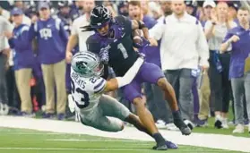  ?? LM OTERO/AP ?? TCU wide receiver Quentin Johnston is tackled by Kansas State cornerback Julius Brents in the first half of the Big 12 Conference championsh­ip Saturday in Arlington, Texas.