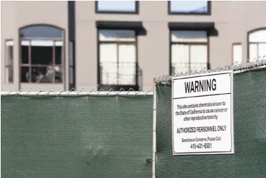  ?? Paul Chinn / The Chronicle ?? A sign at a condominiu­m constructi­on site at 1598 Bay St. warns of hazardous material in the Marina.