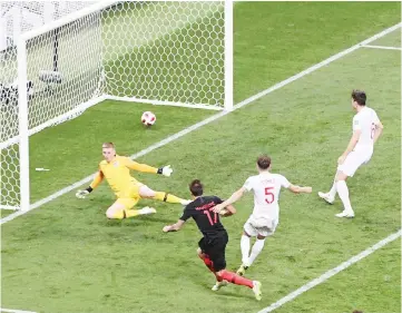  ??  ?? Croatia’s Mario Mandzukic shoots and scores his team’s second goal during the semi-final against England. — AFP photo