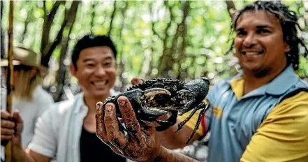  ??  ?? Juan Walker, right, from Walkabout Adventures, with the now-famous mud crab.